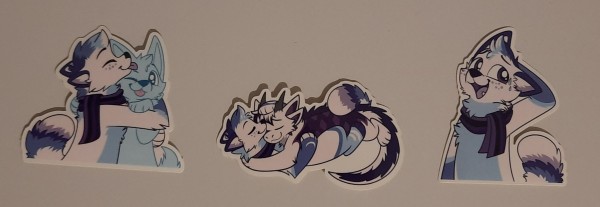 Three of my stickers lying on a table in a row. From left to right: Hugging a ych, cuddling with Karb and nervous laughter