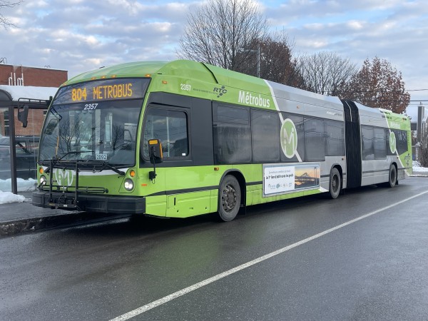 An articulated bus with the fleet number 2357. It has a grey and green livery with "Métrobus" lettering. The destination sign reads "804 Métrobus", and the bus is on a wet road.