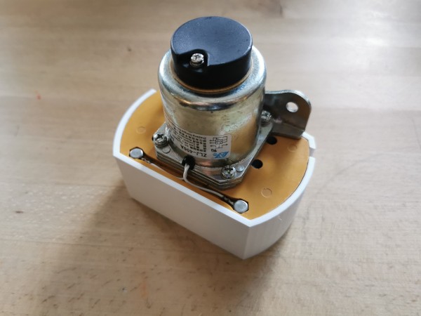 A 400A contactor seen from the back, with a 3D printed white cover on it. 