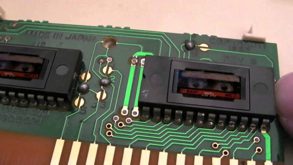 A closeup of a ROM simm, with a pair of very tiny 24-pin DIP cassette decks soldered to the board. Inside them are very tiny BASF cassettes.